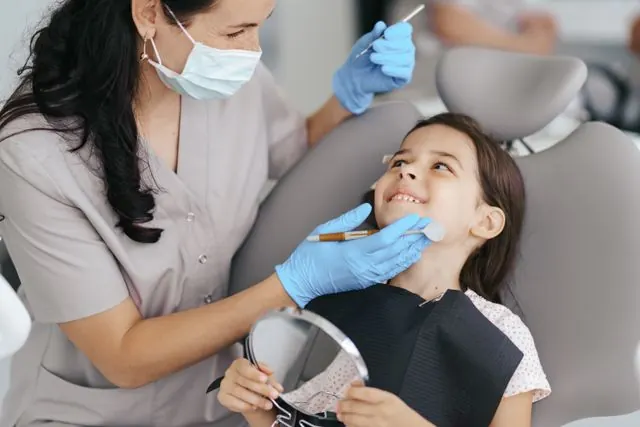 Paediatric dentist treating a child